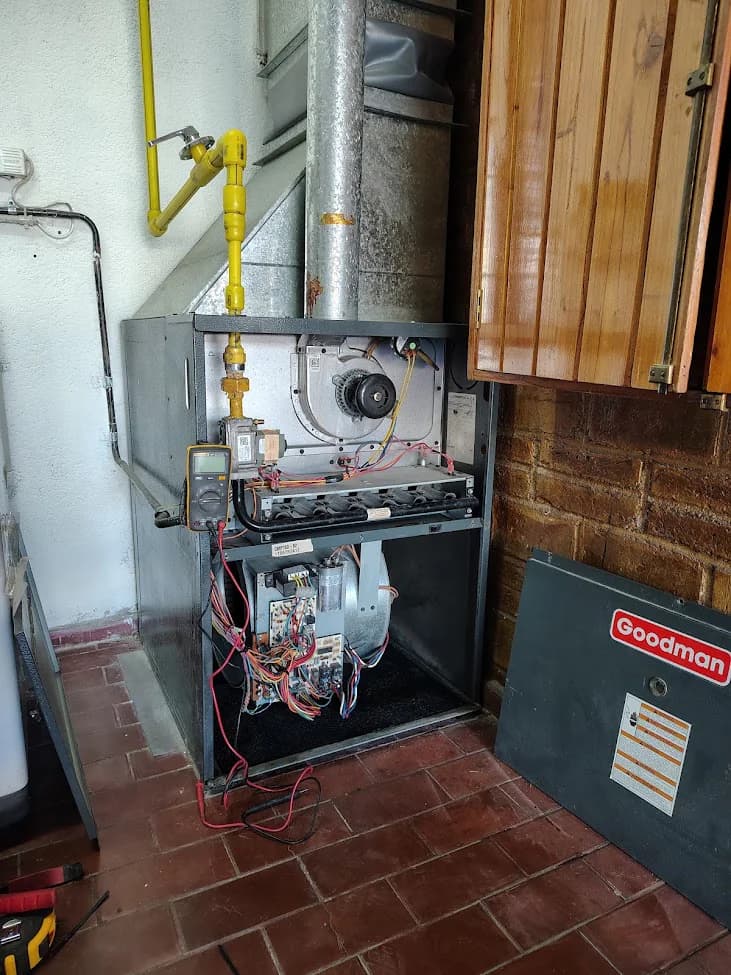 Sistema de calefacción central abierto con cañerías, cableado y componentes internos expuestos.